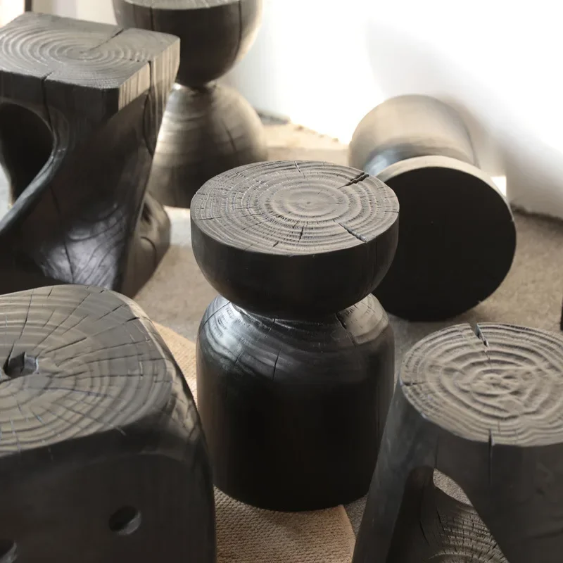 A few carvings on the side of the wabi-sandy wind solid wood stump, a few low stools on the sideof thecarbonized black logpie