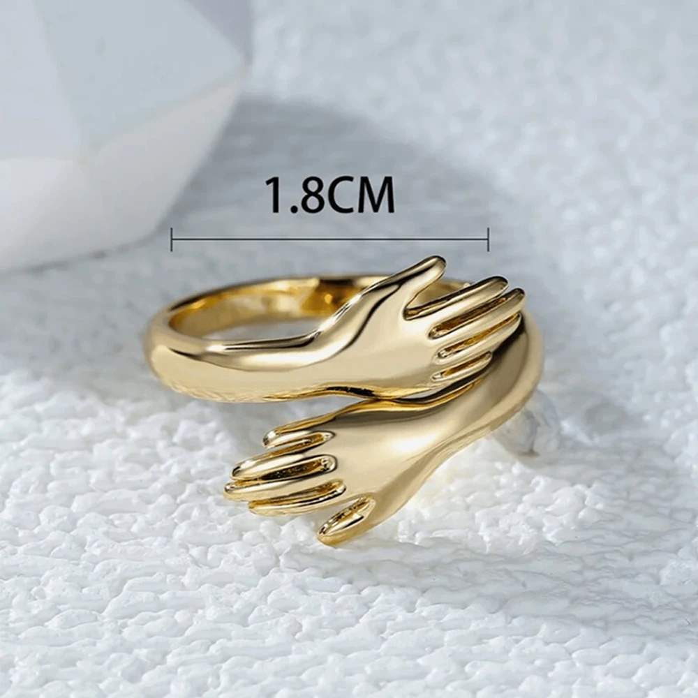 خاتم عناق عصري ثلاثي الأبعاد، لون ذهبي مع تصميم متشابك لليدين، تفاصيل رائعة وملمس كامل، مناسب للارتداء اليومي