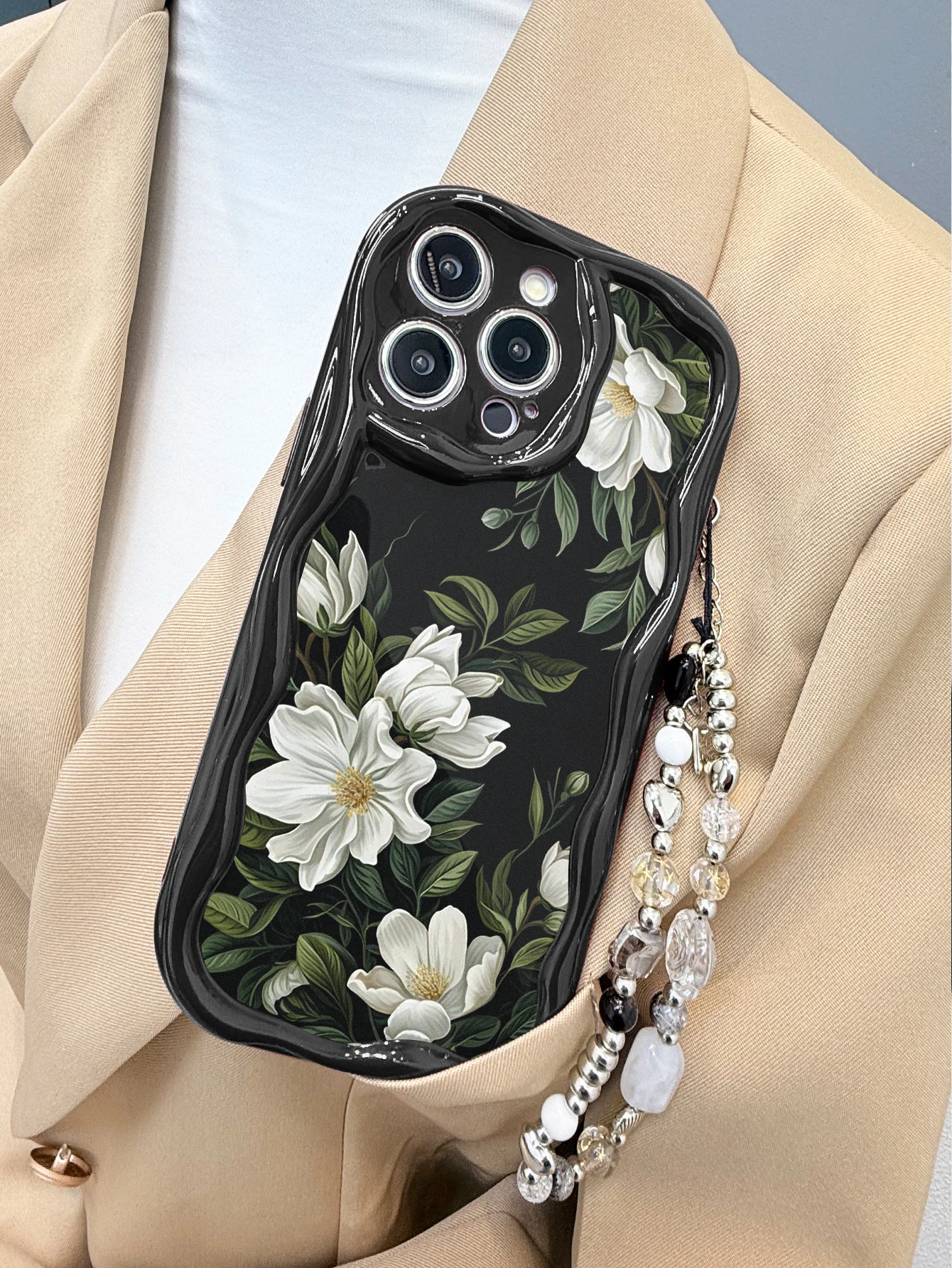 Funda Protectora para iPhone 16 15 14 13 Pro Max con Diseño Floral de Magnolia Blanca, Borde Ondulado Negro y Cadena de Muñeca con Cuentas Plateadas Mixtas