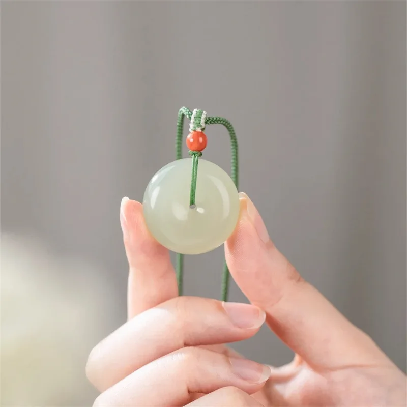 A simple, light green pendant featuring a Qing water design, with a blue-white jade safety clasp
