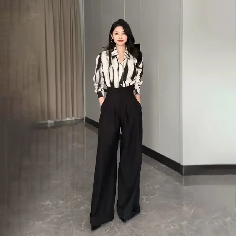 

Женский комплект из двух предметов: рубашка с абстрактным принтом в черно-белых тонах и брюки с высокой талией и широкими штанинами