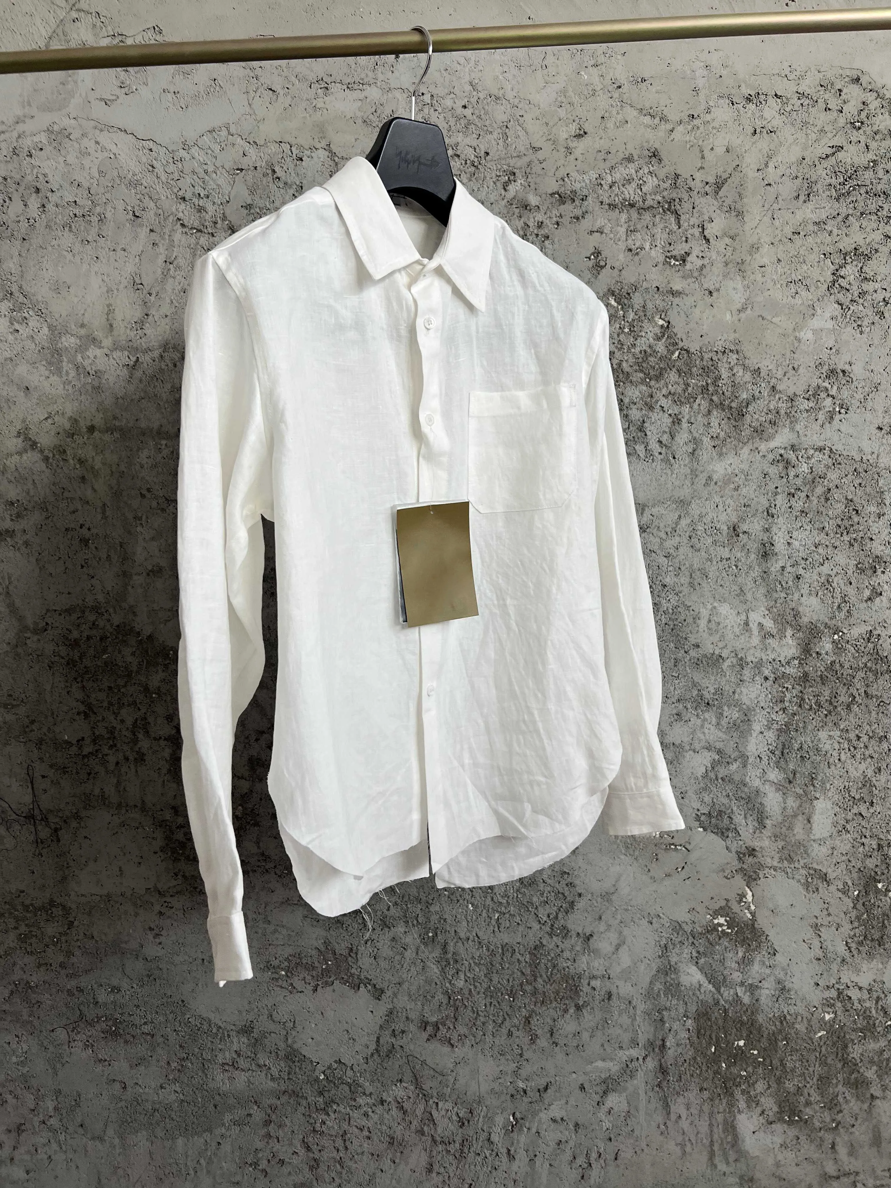 A long-sleeved single-breasted shirt with a simple back patchwork design and letter print for a white man