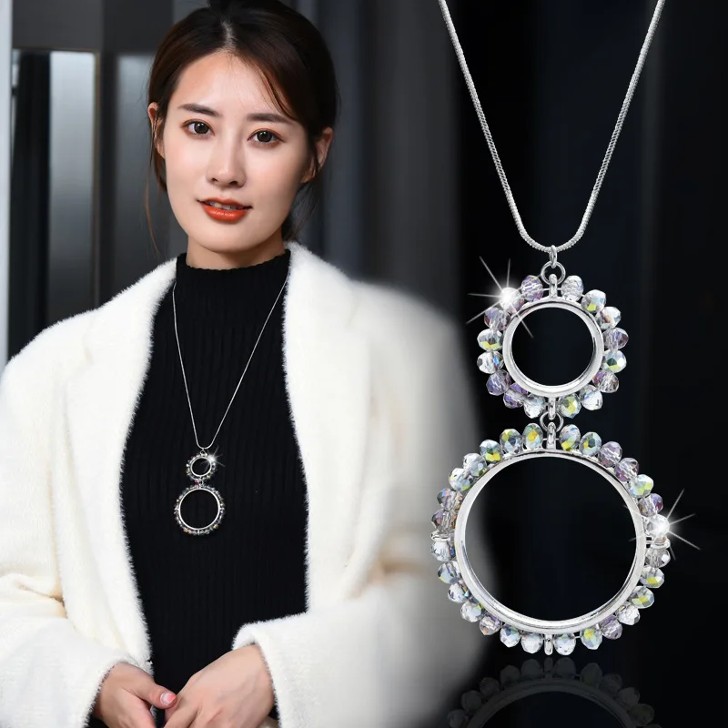 Una semplice nuova collana lunga a doppio anello, abbinata a una catena di maglioni di cristallo di diamanti nel cerchio della moda delle donne alla moda