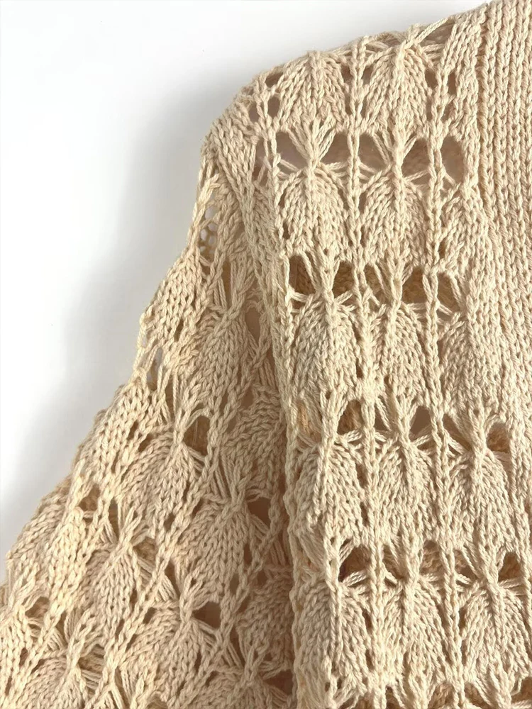 Europejskie i amerykańskie trendy jesiennej kolekcji damskiej: dzianinowy kardigan z krótkim rękawem, dekoltem w serek, sznurowaniem i łączonych elementów.