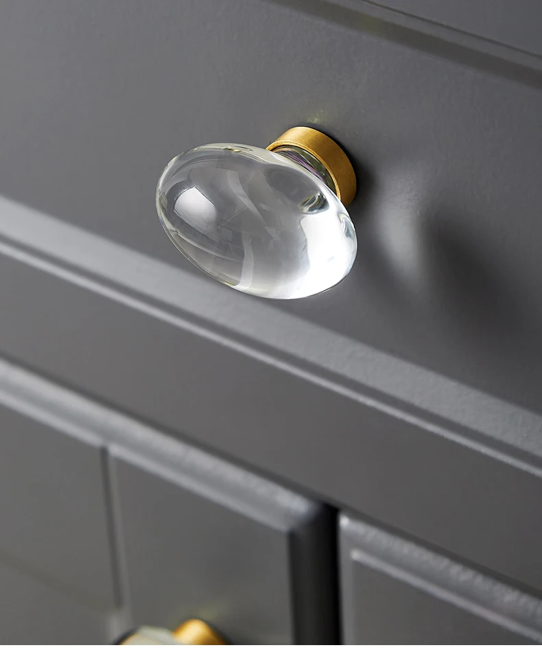 Smooth clear oval glass knob fitted to a grey drawer