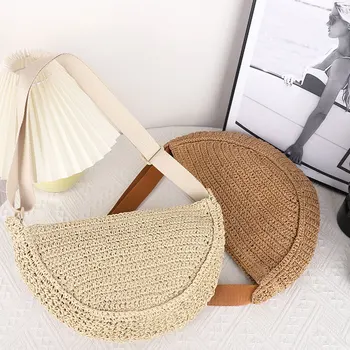 Półokrągła, ukośna, tkana torba krzyżowa wyposażona w praktyczne przegródki i zapięcie na zamek błyskawiczny w kolorze beżowym