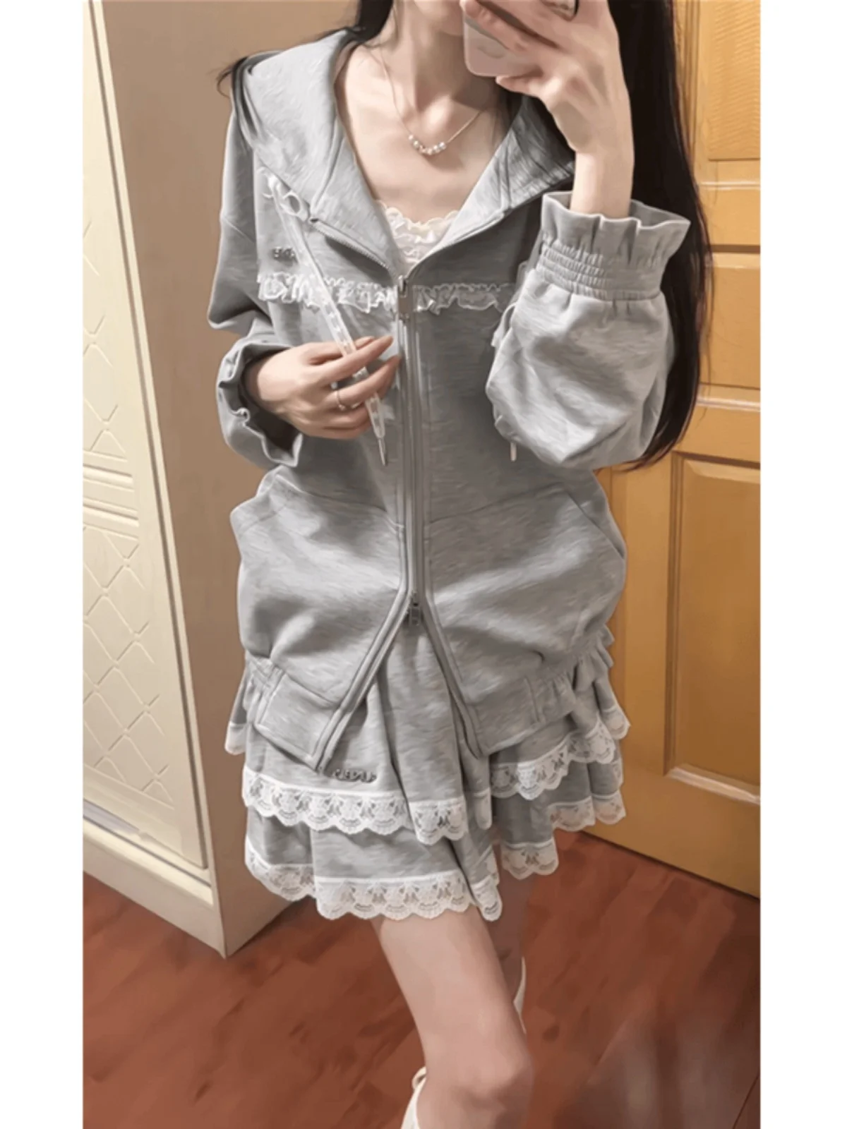 طقم ملابس نسائي مكون من هودي رمادي كوري مزين بكشكشة وتنورة كيك عالية الخصر مزينة بالدانتيل، تصميم فريد وجميل، مناسب لأوائل ال...
