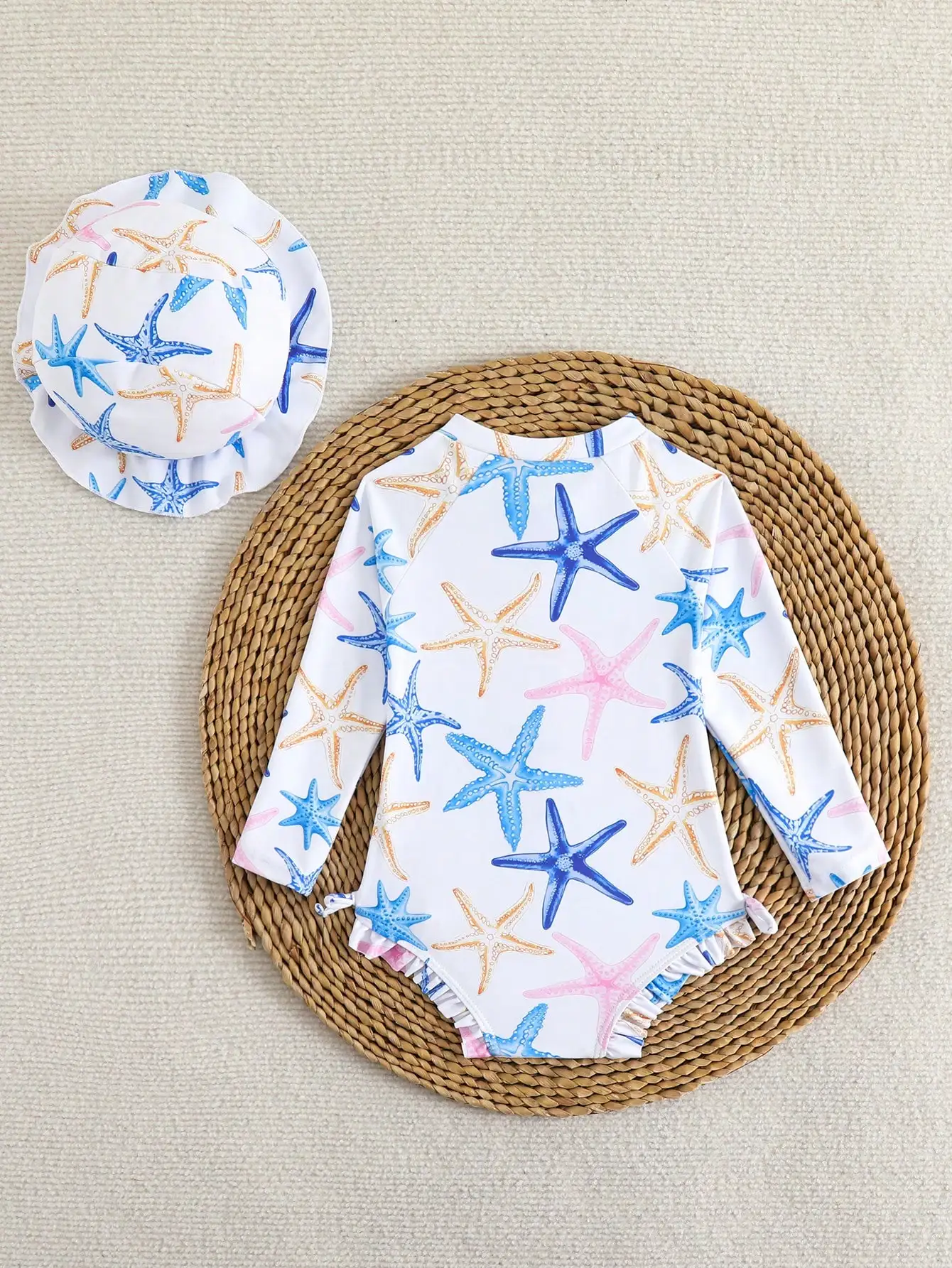 

Комплект для малышек: слитный купальник с длинными рукавами и узором в виде морских звезд, с рюшами по низу и подходящей панамкой от солнца, на молнии спереди, для пляжа