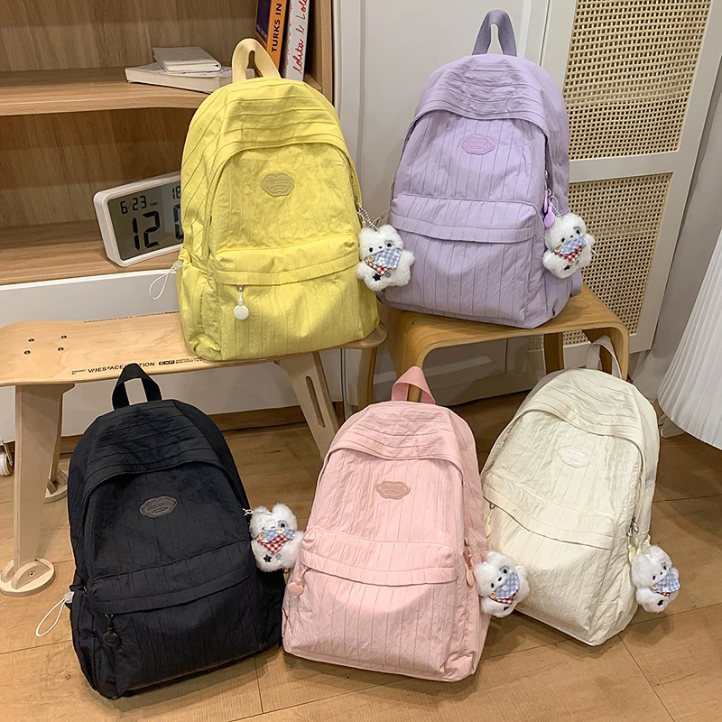 Coreano náilon mochila feminina casual cor sólida pequena mochila de viagem para adolescente mochila escolar com decoração boneca