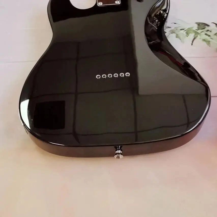 جيتار كهربائي أسود برقبة من خشب القيقب يتميز بلوحة واقية كبيرة وجسم ماهوجني قوي وجودة استثنائية