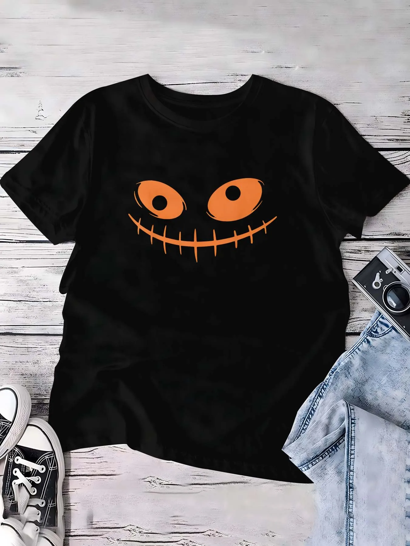 

Футболка больших размеров на Хэллоуин с жуткой и графикой, демонстрирующая игривый дизайн тыквенного лица для модного праздничного образа