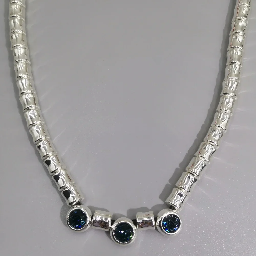 A niche art necklace with blue gemstones, vintage texture, personalized wearing style, and a neckchain
