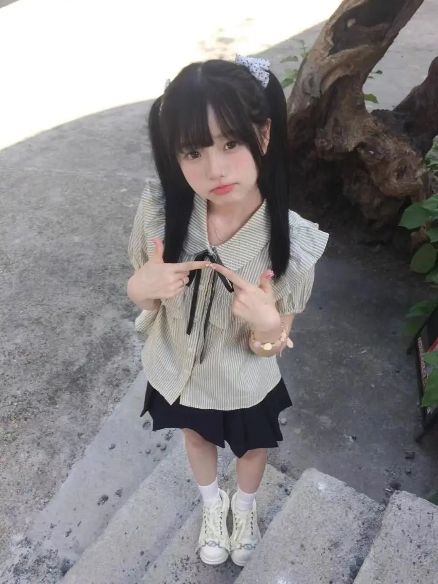 Het zomernieuwe gestreepte shirt met korte mouwen en korte rok uit 2025, een lief meisje