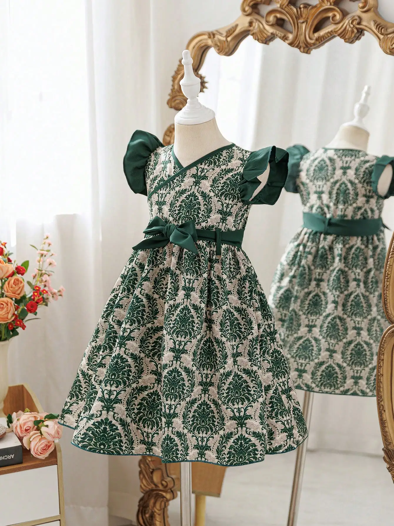 

Элегантное платье с V-образным вырезом, принтом по всей поверхности, рукавами с рюшами и поясом с бантом.