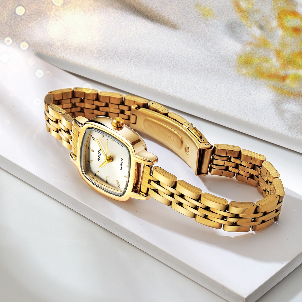 ساعة كوارتز بحزام من الفولاذ المقاوم للصدأ باللون الذهبي وبسيطة في مكان العمل