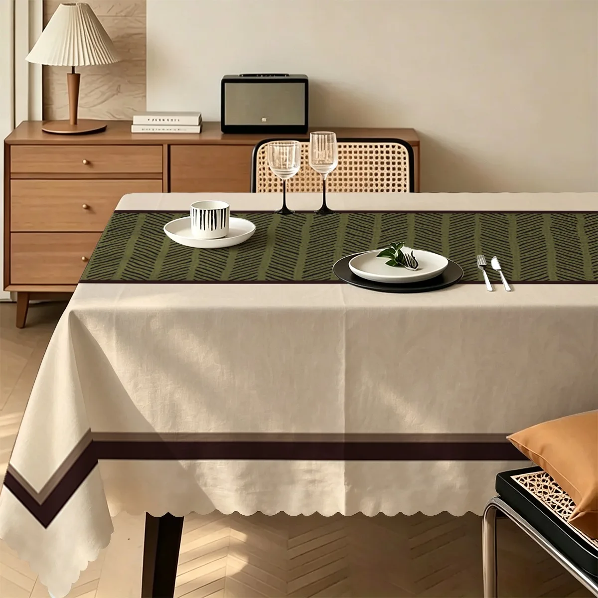 A rectangular tablecloth with a light beige background and an olive green zigzag pattern along the middle as the border