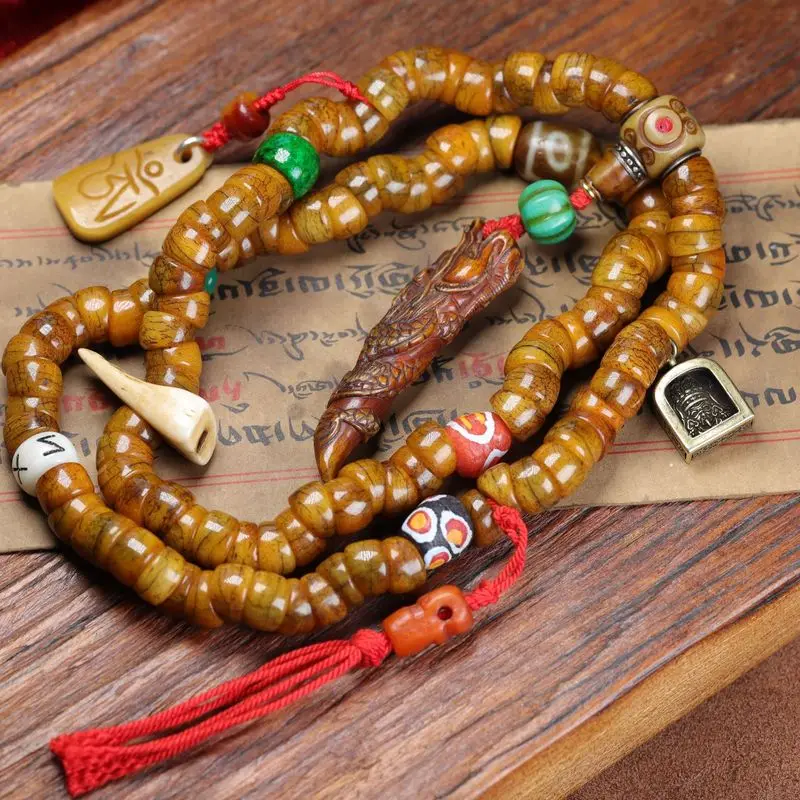 Tibetan-style bracelet featuring a large intestine-shaped charm multiple rows of beads and a handheld design complemented by
