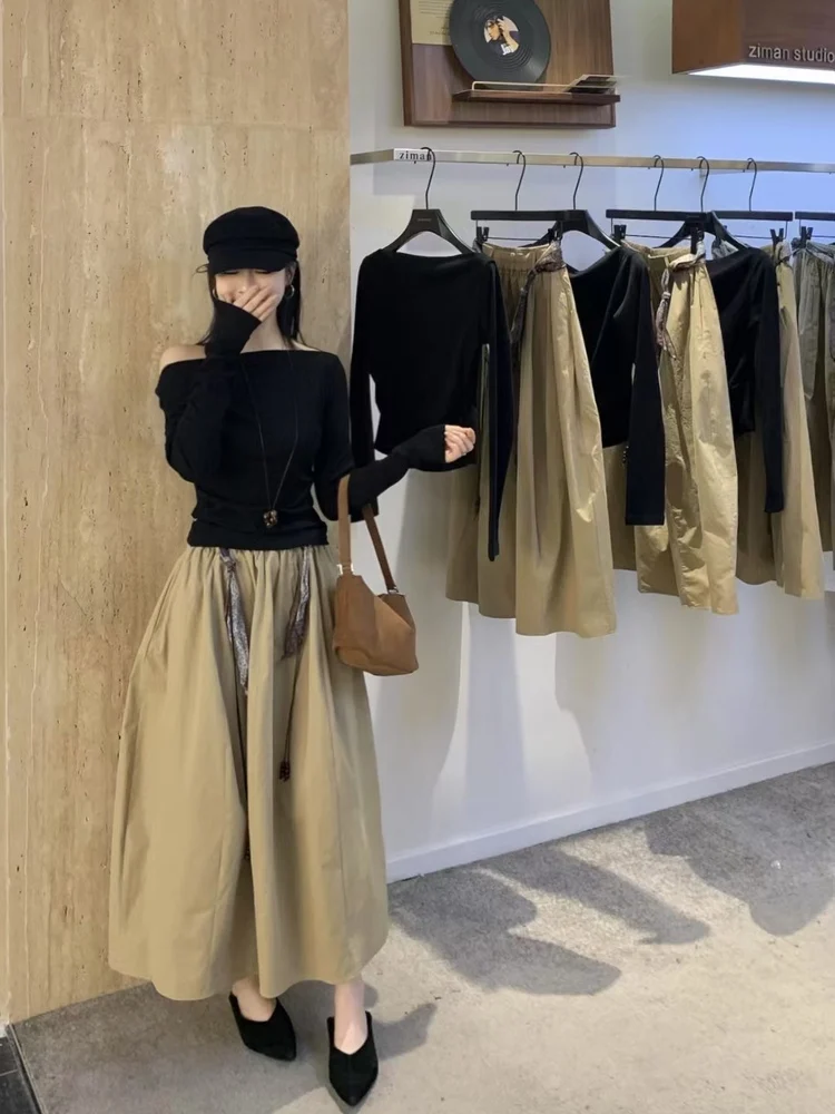 

Элегантный повседневный комплект из двух предметов: женская однотонная футболка и юбка миди с эластичным поясом. Модная осенняя одежда.