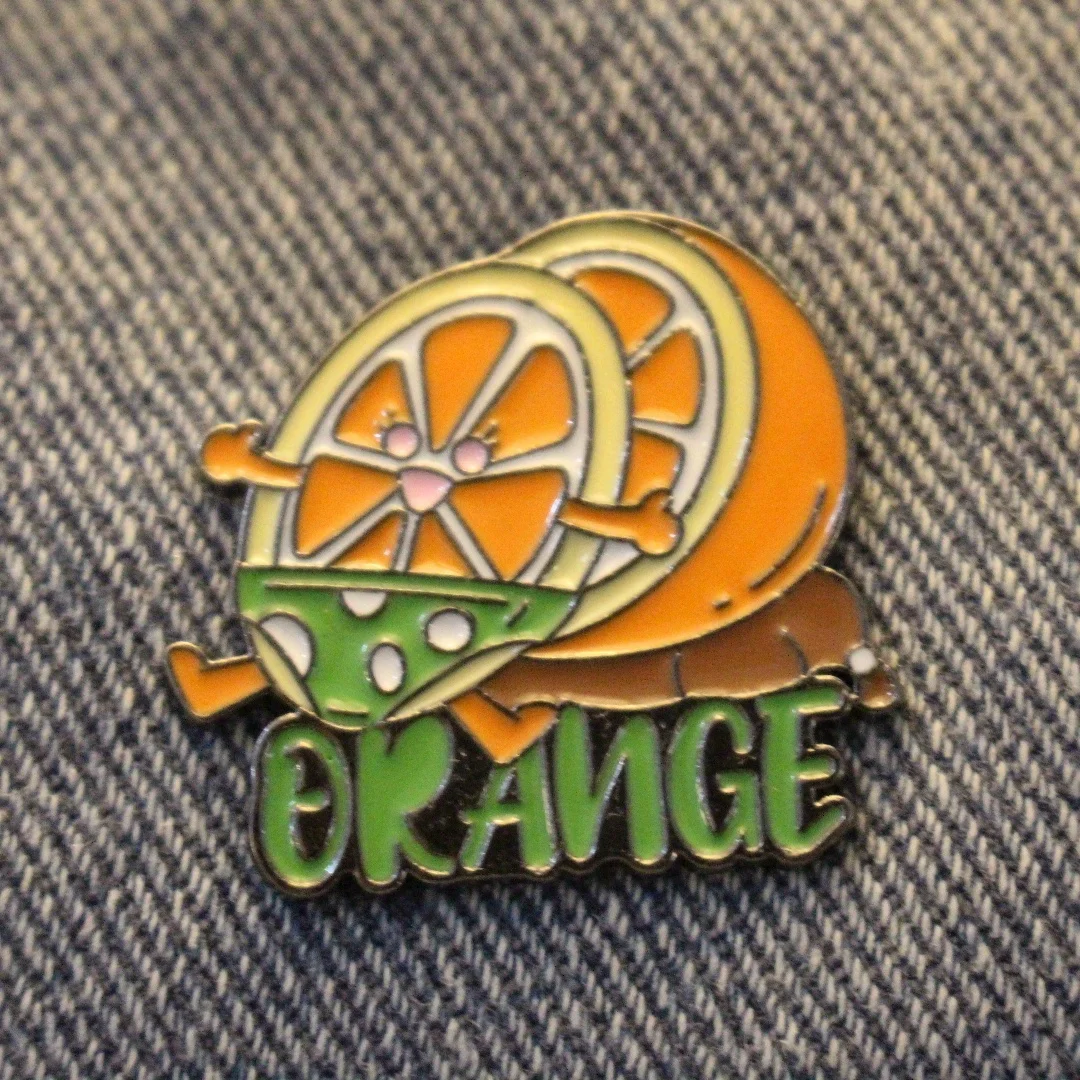 Fun Cartoon Fruit Pin Featuring An Orange, Perfect for Both Men and Women To Accessorize Clothing and Backpacks or As A Gift.