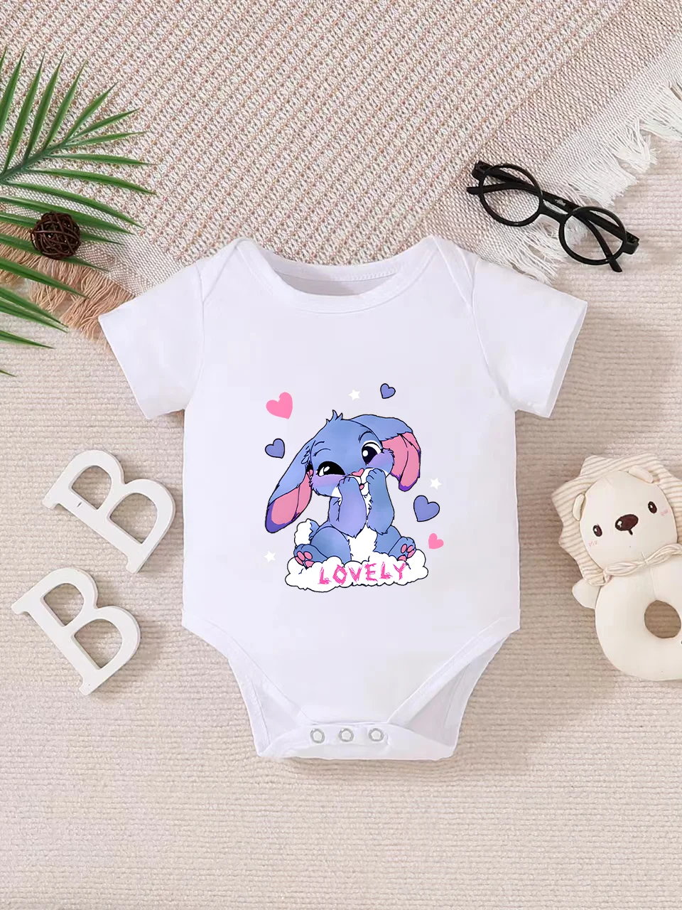 Playful letter-printed baby short-sleeve triangle bodysuit. Button closure for easy dressing, machine washable