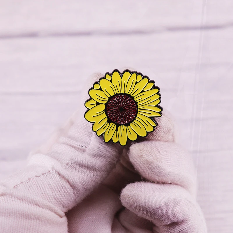 La broche en émail tournesol peut voir le côté lumineux et trouver de l'espoir même dans les temps de croissance