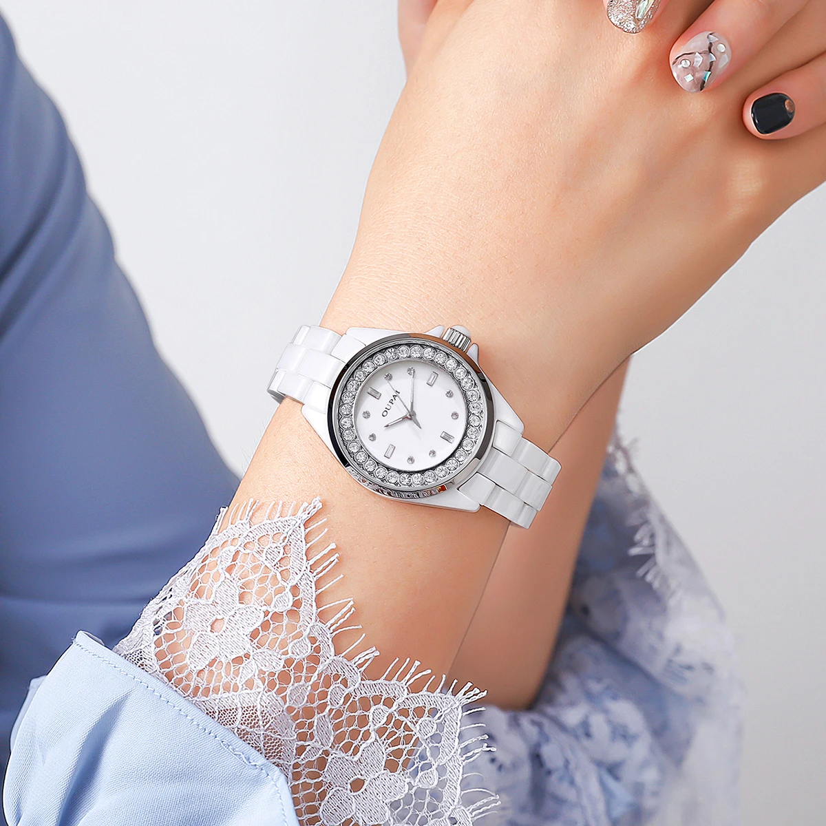 ساعة يد نسائية دائرية من Oupai ساعة سيراميك بيضاء بمقياس حجر الراين كوارتز تتحرك ساعة نسائية أنيقة وعصرية