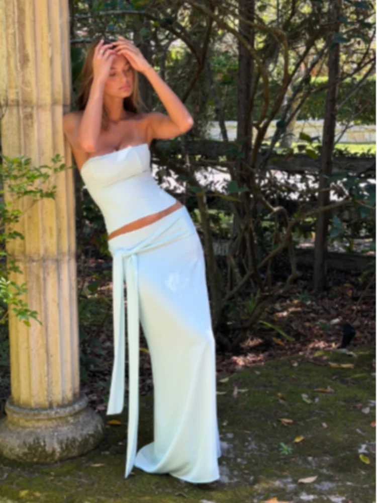 

Женский светло-голубой комплект из двух предметов: сексуальный топ-бюстье без бретелек и облегающая юбка макси с завязками на талии. Новинка 2026 года: летний пляжный наряд для отпуска.