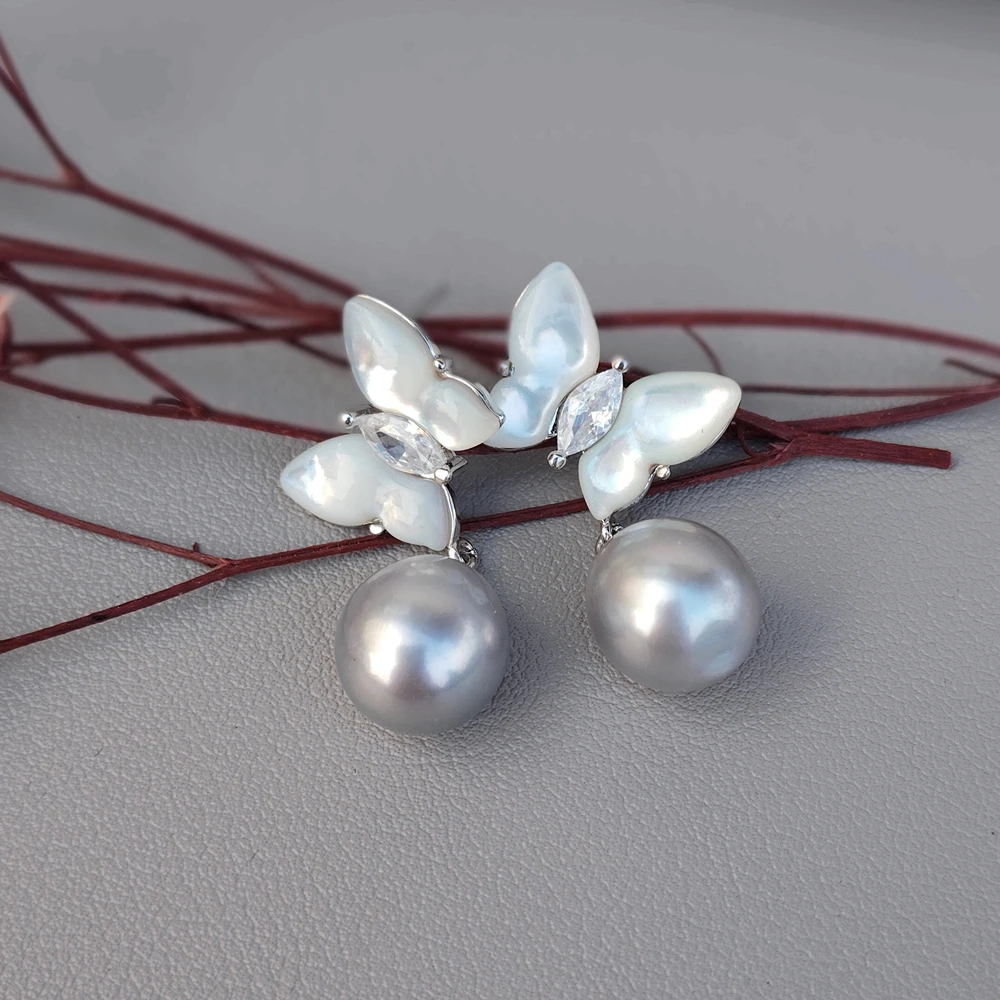 

Серьги-гвоздики KKGEM Natural с серым пресноводным жемчугом 10x12 мм и белой ракушкой в форме бабочки с фианитами