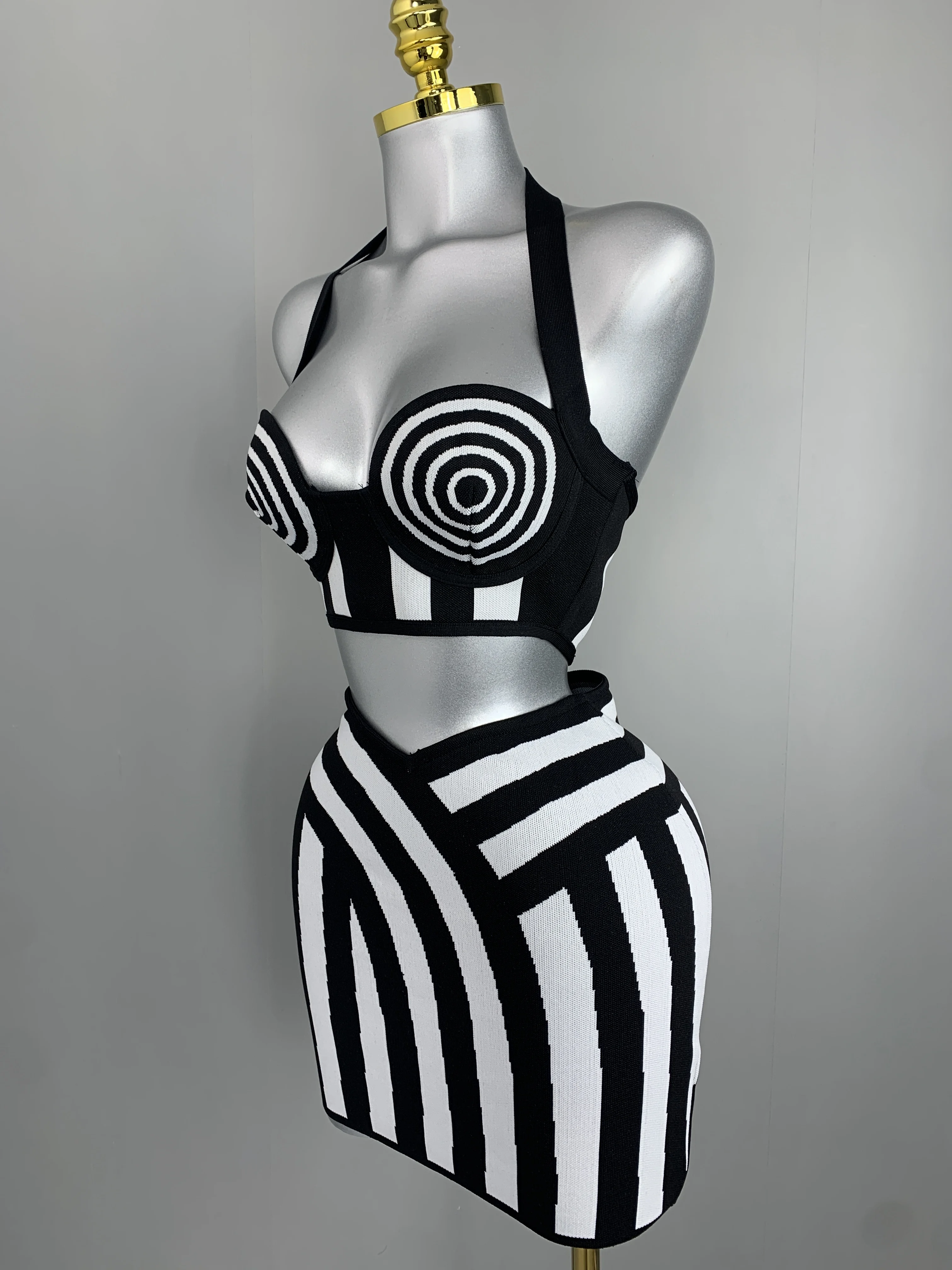 

Женский черно-белый комплект из 2 предметов: укороченный топ с воротником-халтер и спиральным принтом, облегающая мини-юбка в полоску с завязками. Наряд для вечеринок, свиданий, клубов.