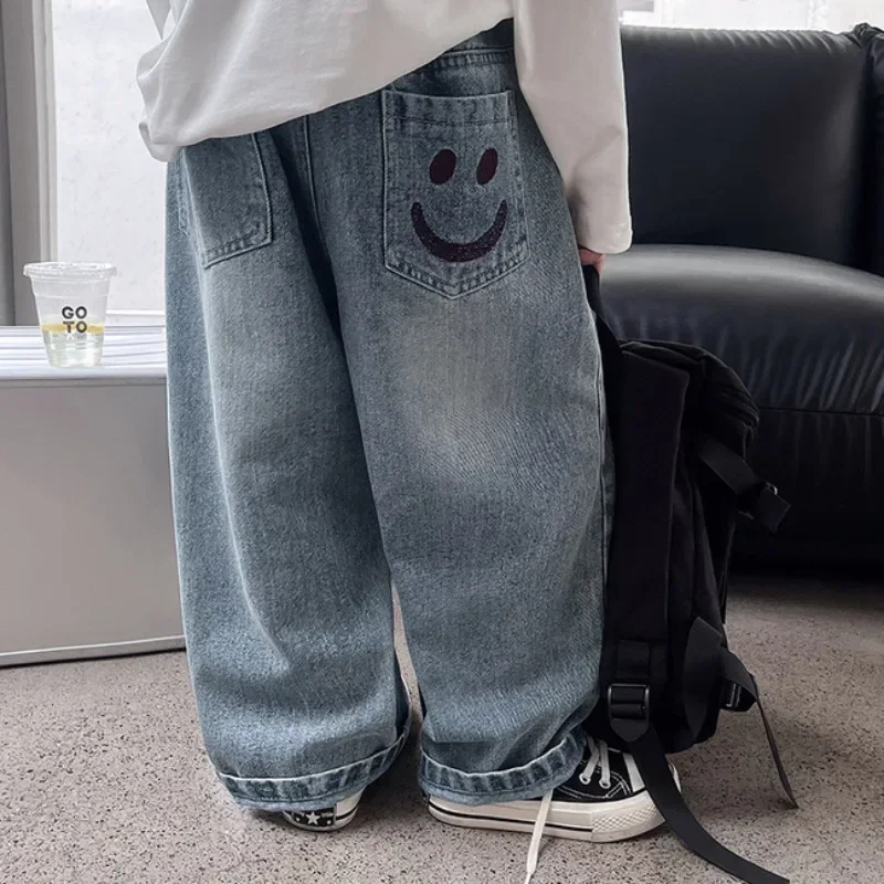 Novo 2025 meninos moda rosto sorridente bordado jeans calças compridas criança clássico solto calças jeans crianças primavera outono roupas