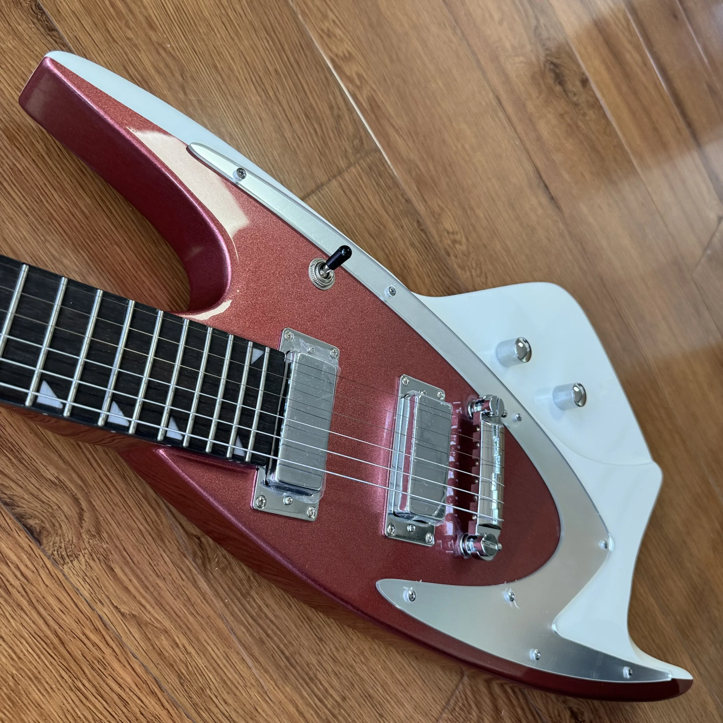 The Electric Guitar Features A Color Scheme Of Metallic Red And Ivory White. It Is Equipped With Silver Metal Guards.