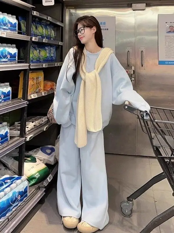 

Комплект из трех предметов: женский повседневный свитшот больших размеров, шаль и свободные брюки с широкими штанинами. Модный осенне-зимний тренд.