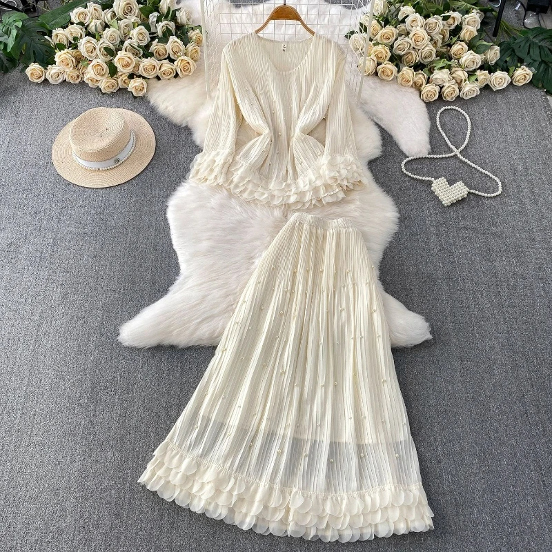 

Женский весенний комплект из двух предметов: топ с круглым вырезом и рюшами, свободного кроя, и плиссированная юбка с высокой талией.