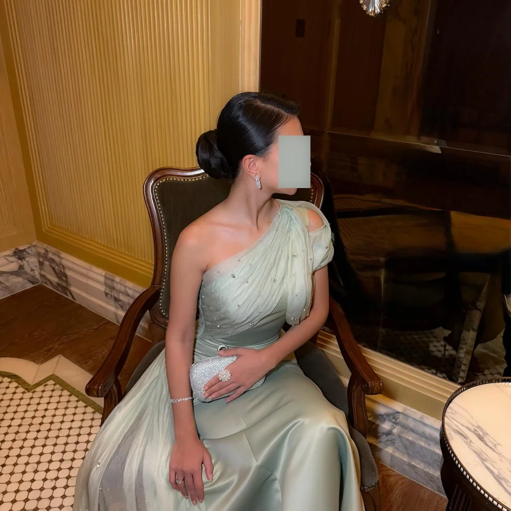 Bella Maßgeschneidertes grünes Glitzer-Abschlussballkleid mit schrägen Schultern, A-Linie, Satin, rückenfrei, knöchellang