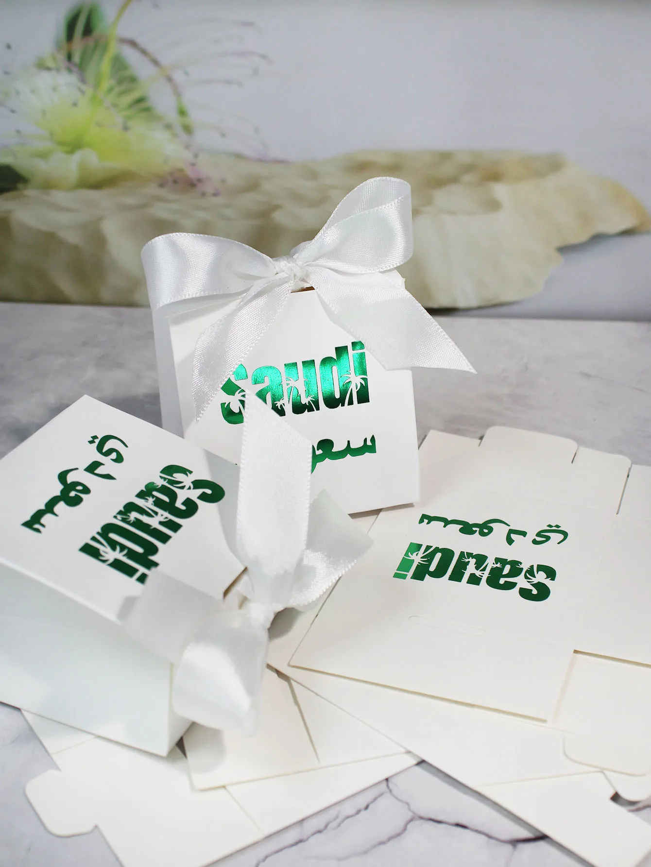 Charming green gift boxesDecorated with gold lettering, hollowed out palm trees, and Arabic script, ideal for festive events