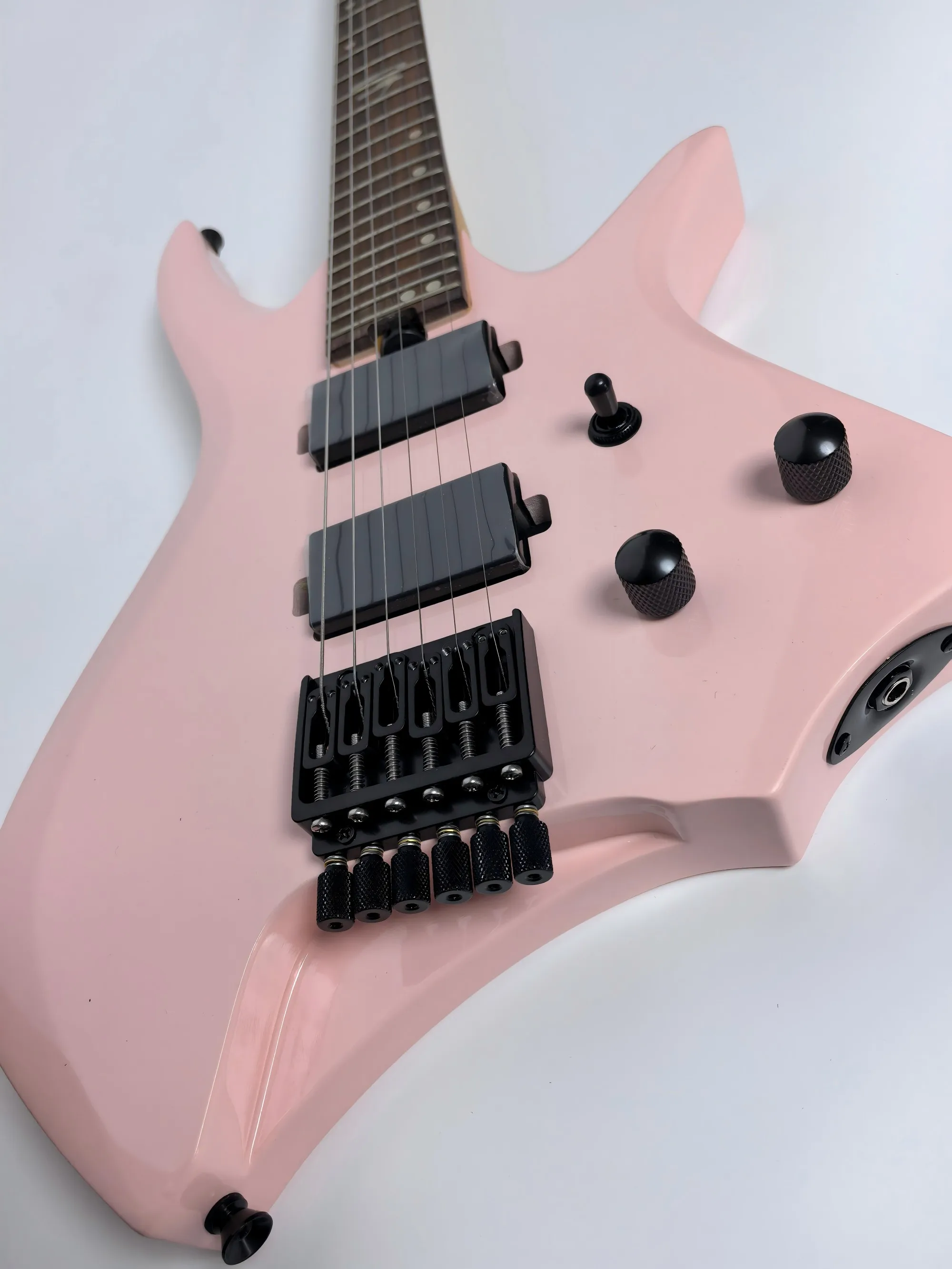 In stock. Can be shipped when placed. High quality pink headless 6 string electric guitar. Factory direct. Can be customized.