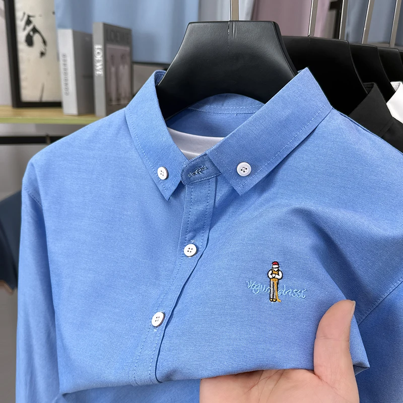Camicia a maniche lunghe da uomo di moda leggera e di lusso, ricamo di cartoni animati di marca, top con risvolto da golf casual in tinta unita business di alta qualità