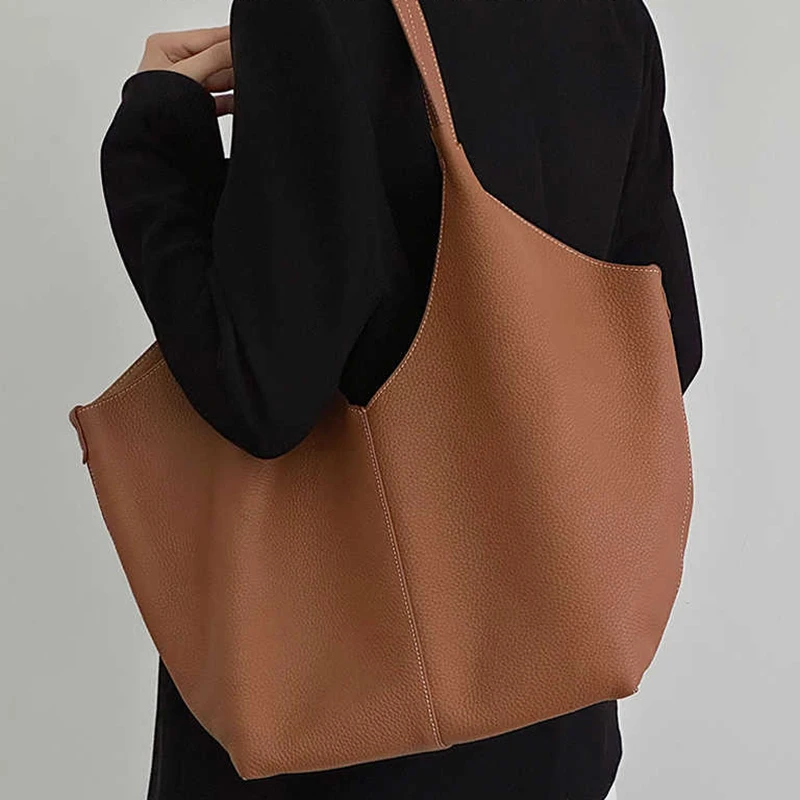 Sac fourre-tout en cuir de vache avec couche supérieure, nouveau design de niche, sac à main simple de grande capacité pour les déplacements, sac à bandoulière sous les bras pour dames, 2025