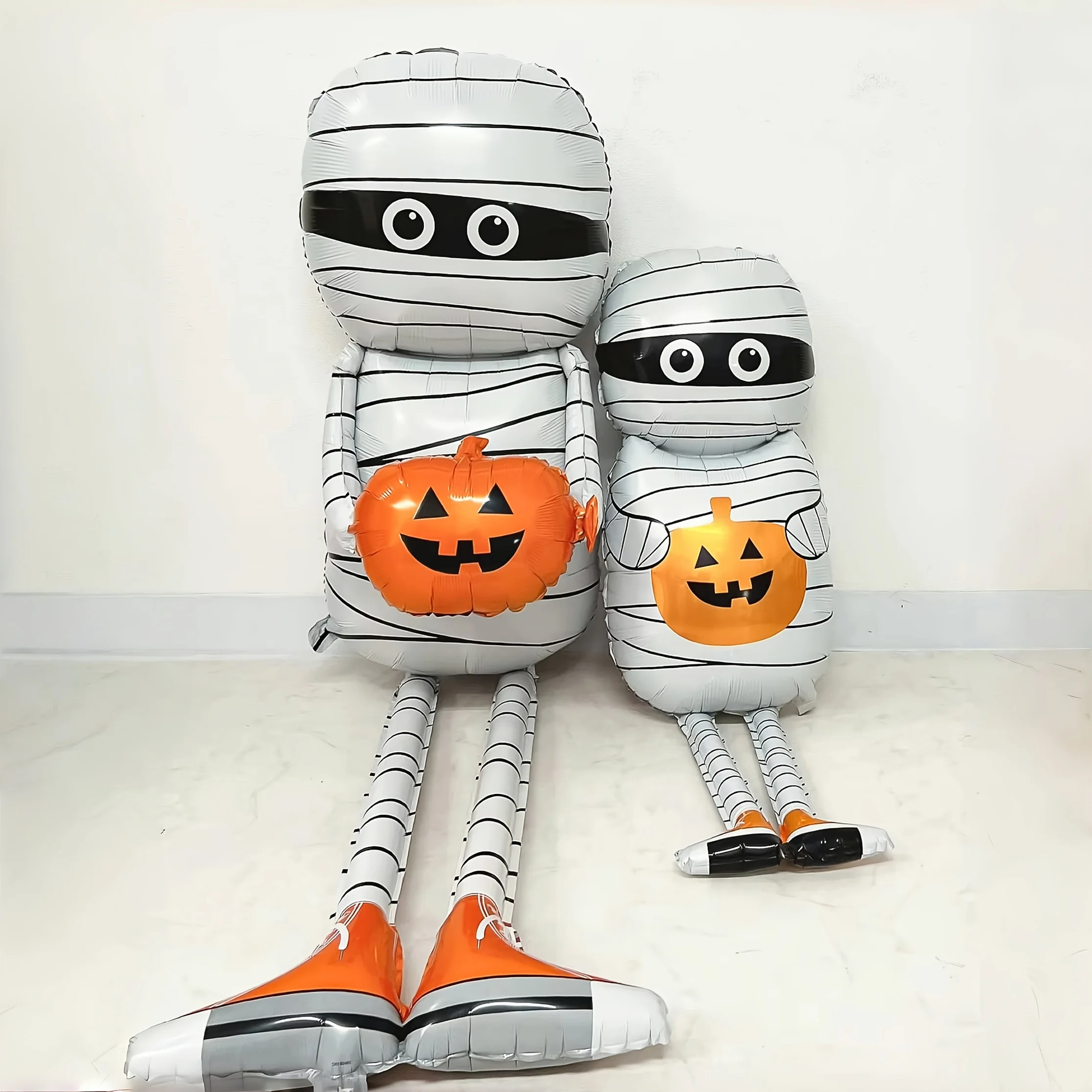 مومياء تحمل بالون من رقائق الألومنيوم اليقطين باللون الأبيض والبرتقالي لعناصر رعب لتزيين حفلات الهالوين