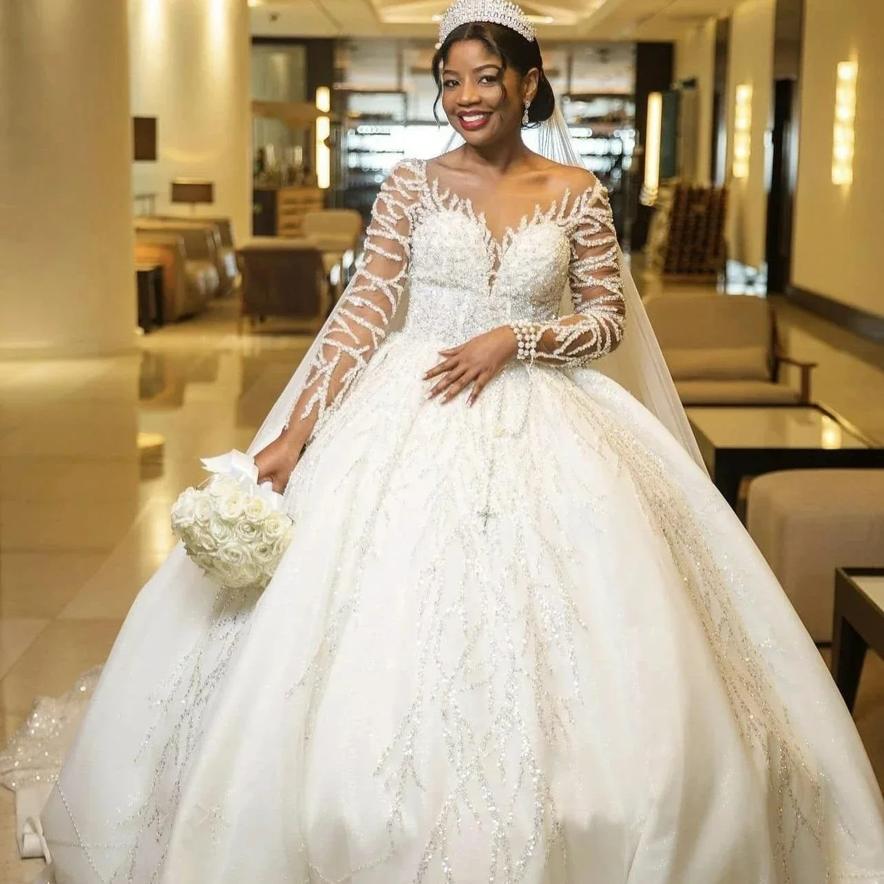 ชุดแต่งงานเจน แอร์ แบบคอวีประดับลูกปัดและเลื่อมวิบวับ พร้อมชายกระโปรงยาวแบบลากพื้น แขนยาว