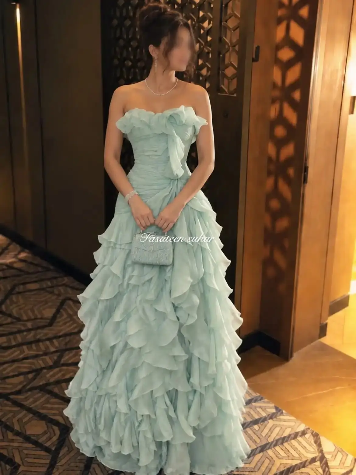 Vestido de noche sin tirantes de color verde menta de la marca LumiGown, con volantes y capas de gasa, ideal para eventos formales, con un gran lazo y un largo hasta el suelo, disponible en talla personalizada.