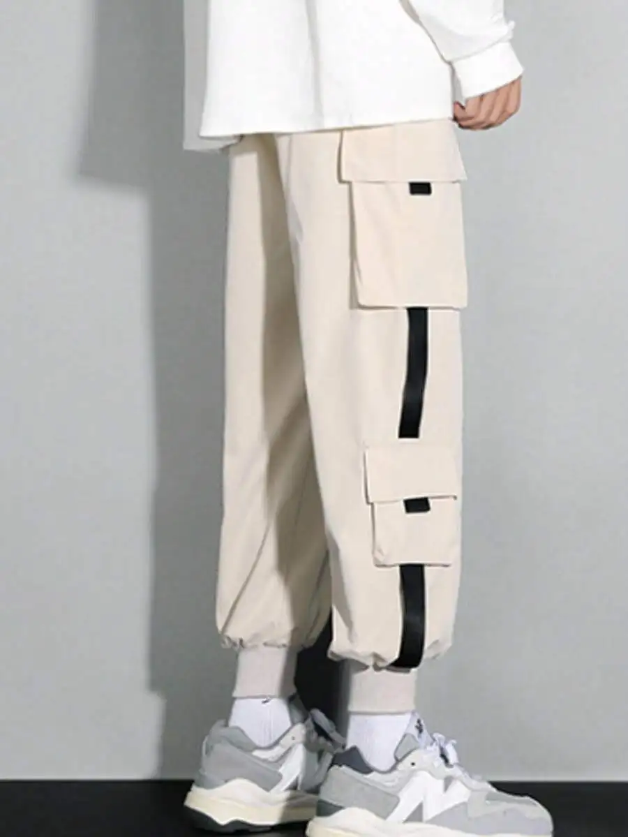 Pantalones cargo utilitarios beige para hombre con detalle de rayas verticales y puños ajustables