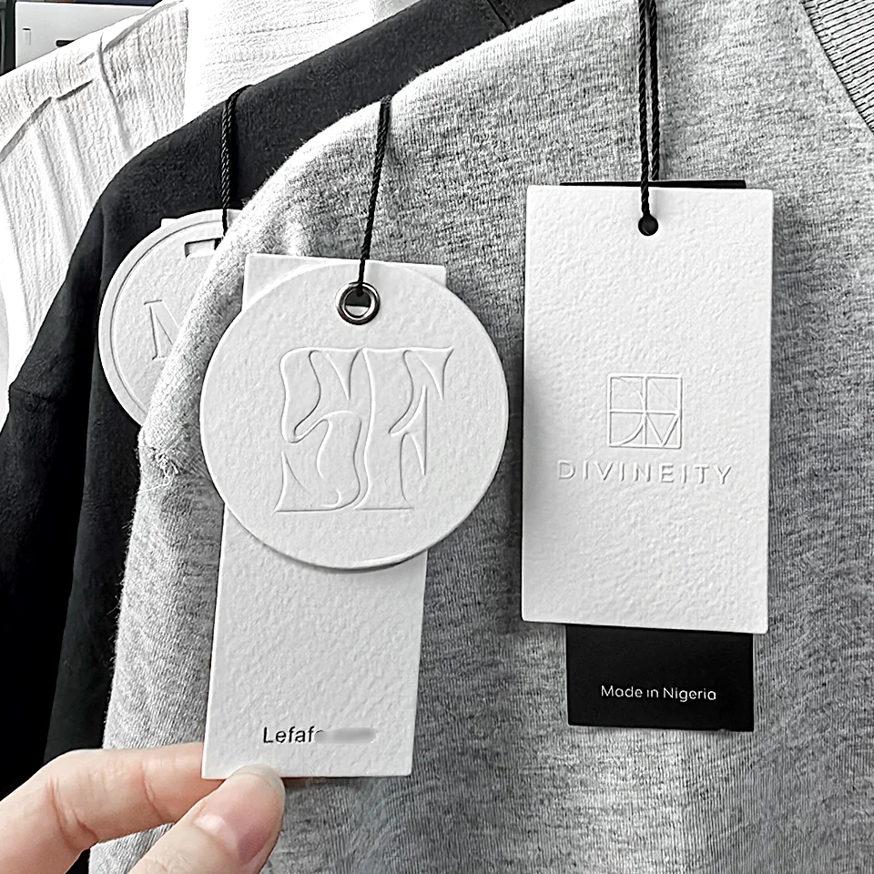 Niestandardowe wytłoczone LOGO biała kartka na ubrania z nadrukiem papier tagi Swing na metki ze sznurkiem