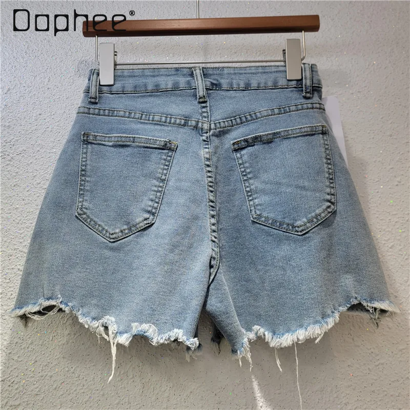 Pantaloncini di jeans personalizzati della stazione europea Donna 2025 Estate Nuova tendenza Perline strappate Ricamo floreale Pantaloni slim a gamba larga Alla moda