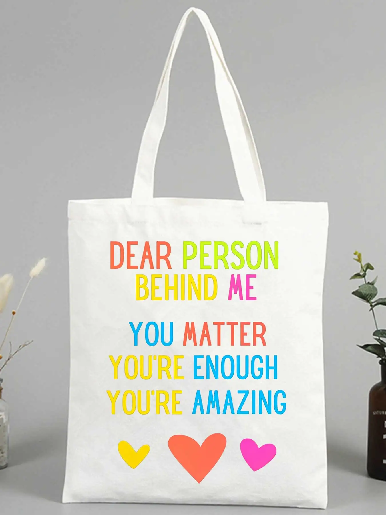 Women's slogan-style canvas tote bag with colorful heart graphics, ideal for daily use and casual outings
