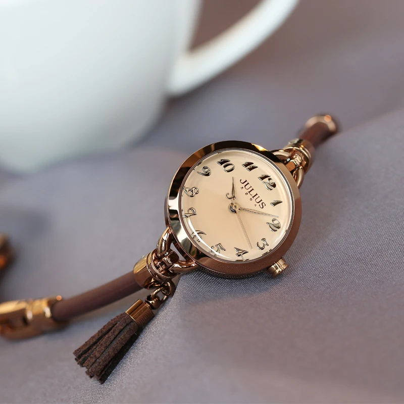ساعة نسائية على الطراز الكوري بحزام رفيع وحزام جلدي رقيق وشرابة على الطراز القديم. ساعة وإكسسوار للنساء.