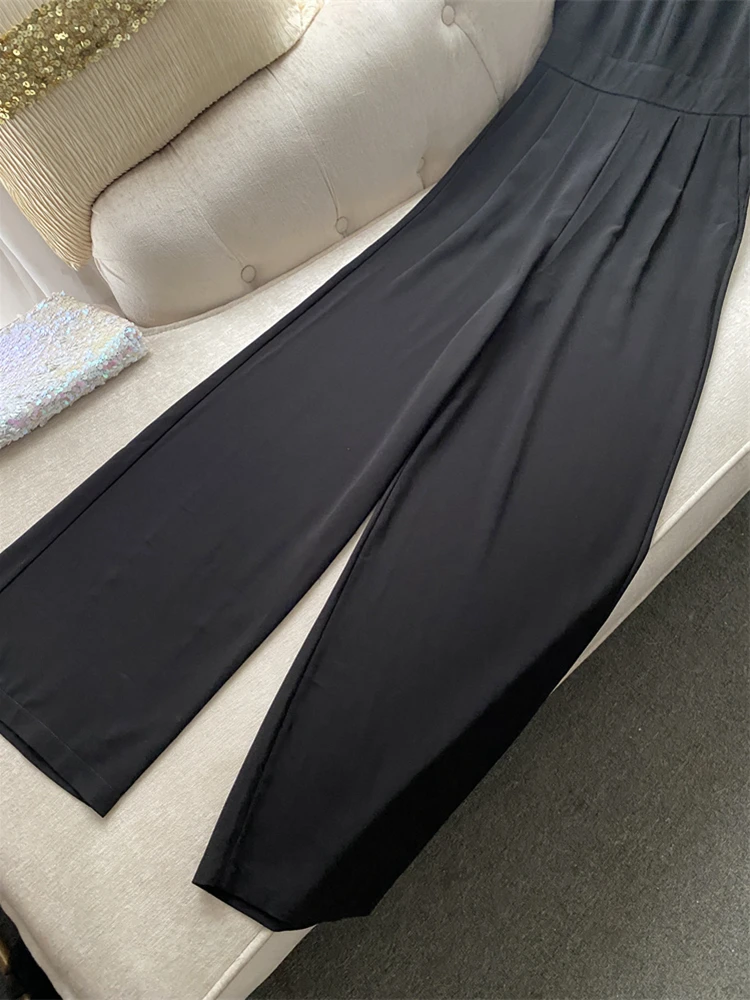 Modny, polecany kombinezon damski z odkrytymi ramionami, z jedwabiu, z podkreśloną talią, długie spodnie, letni strój jednoczęściowy.