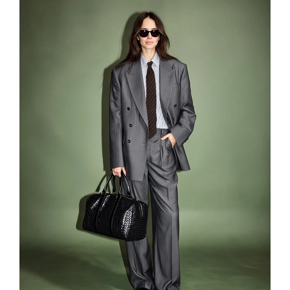 

Высококачественный женский костюм-двойка (пиджак и брюки) в тонкую полоску светло-серого цвета, двубортный, с острыми лацканами, свободного кроя, для офиса