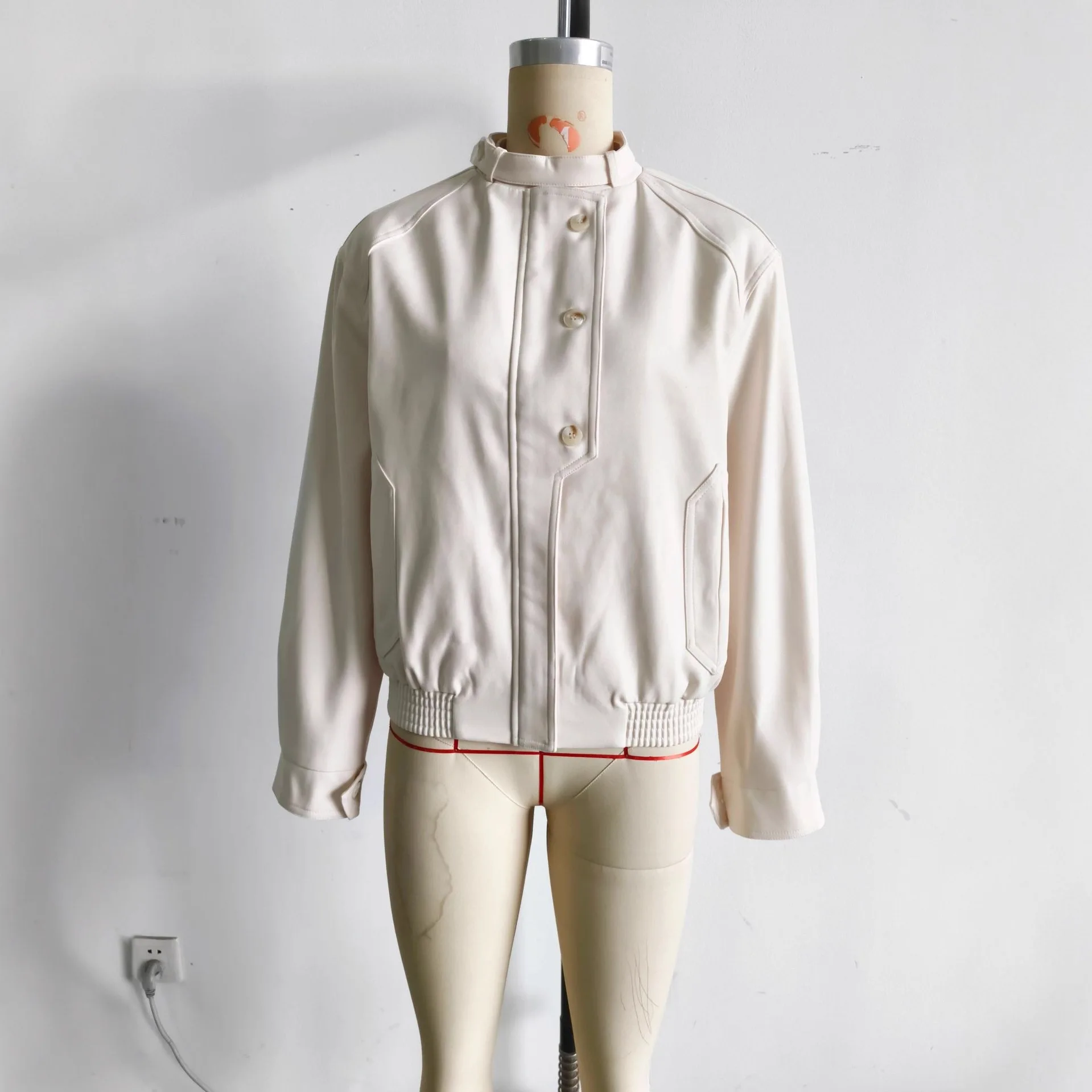 Jesienna moda: luźny płaszcz damski z dwukolorowymi guzikami, casualowy, zapinany na zamek, z wysokim kołnierzem i kieszeniami.