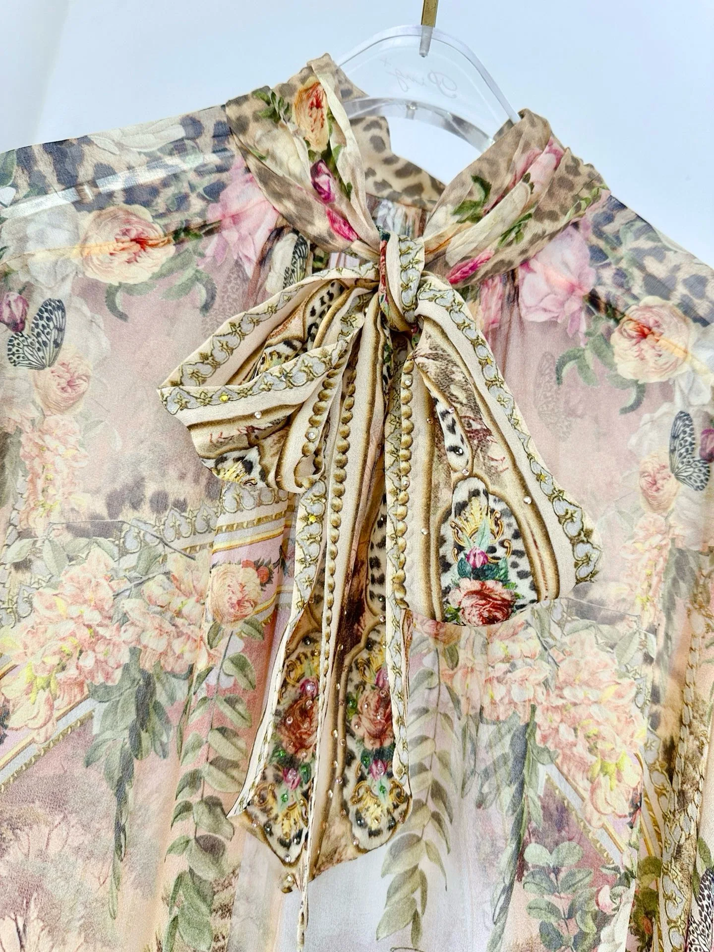 Damska sukienka z wysokim dekoltem, rękawami typu nietoperz, luźna, długa, jedwabna, w różowy wzór w panterkę.